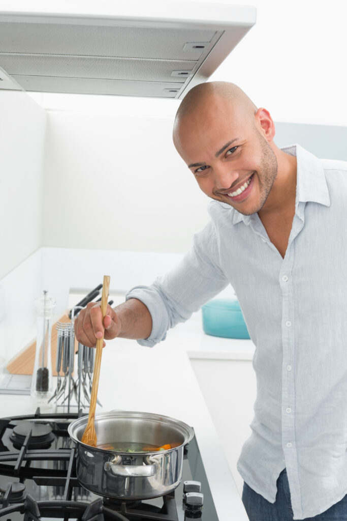 smiling young man preparing food kitchen